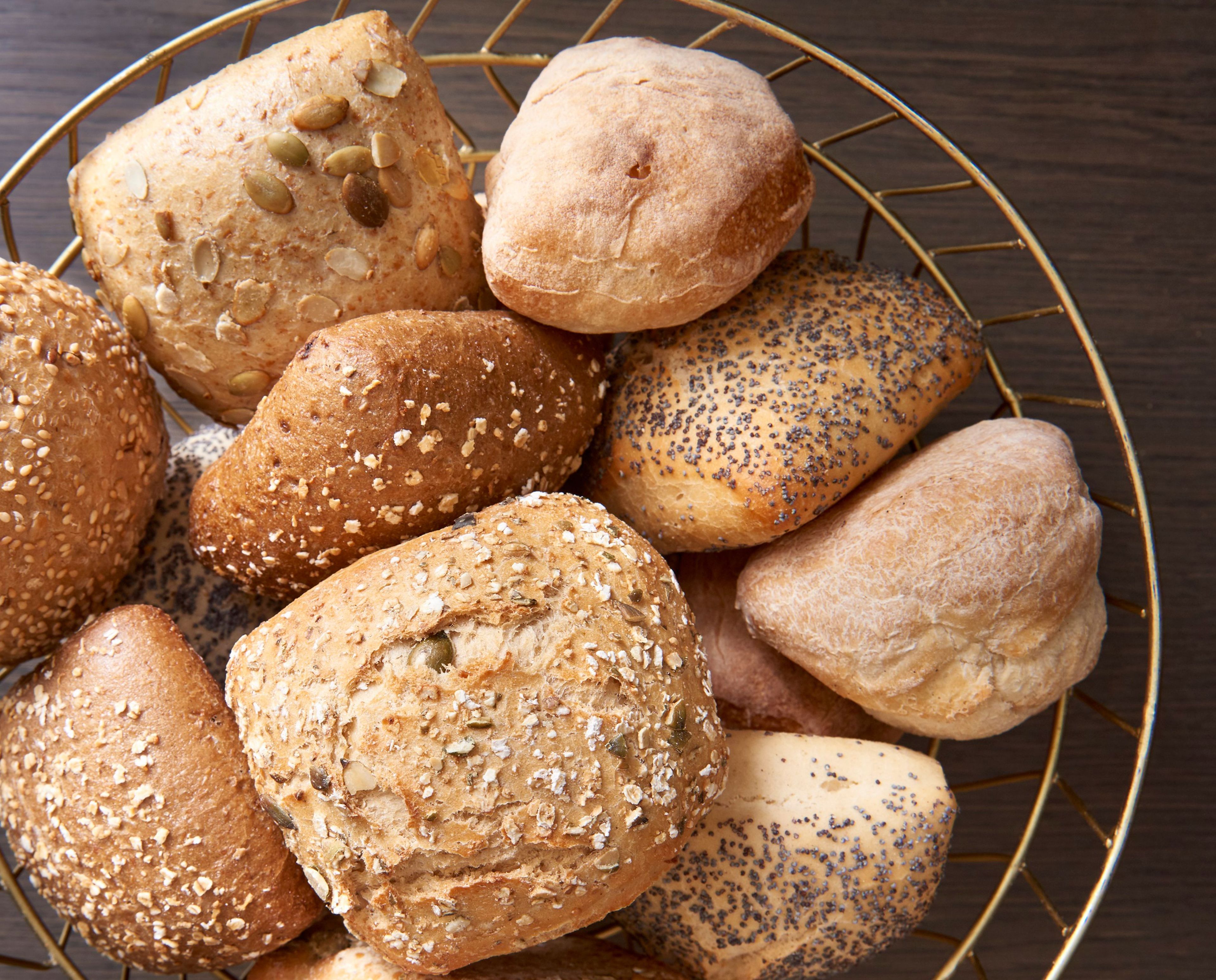 A variety of breads in a wire basket.