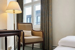 A hotel room with a bed, a chair, a desk, a lamp, and a window with curtains. - Four Points Flex by Sheraton Roskilde (Roskilde)
