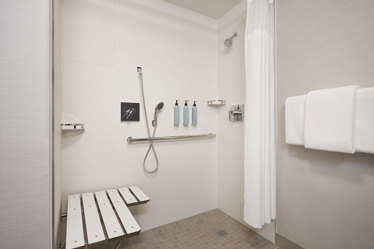 Ein modernes Badezimmer mit Dusche, Handtrockner und Handtuchhalter.