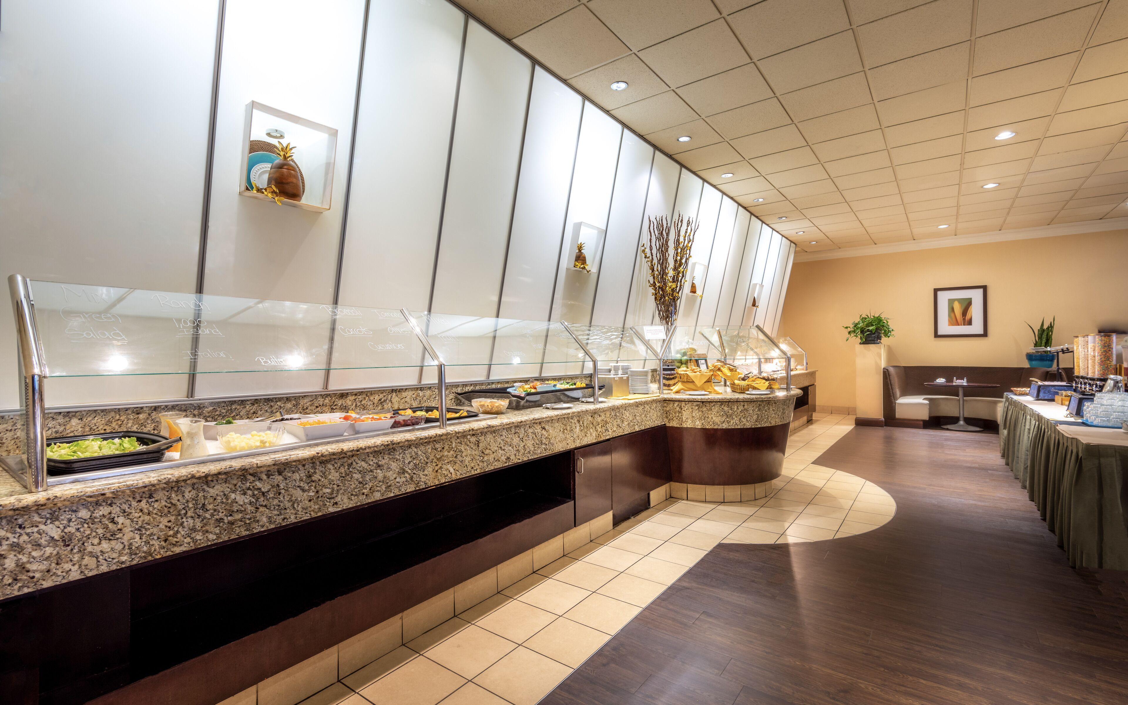 A buffet area with various food options and a seating area with tables and chairs.