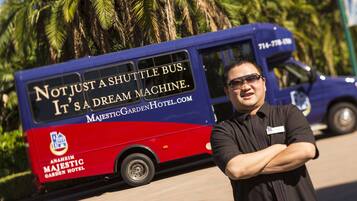 A shuttle bus with the text "Not just a shuttle bus. It's a dream machine." and "Anaheim Majestic Garden Hotel".