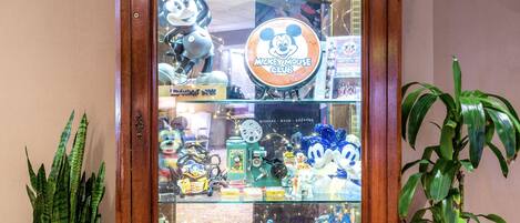 A wooden display cabinet with glass doors, containing various collectibles and figurines.