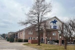 Un edificio de ladrillo con un cartel que dice "Baymont by Wyndham" y la silueta de un caballo.