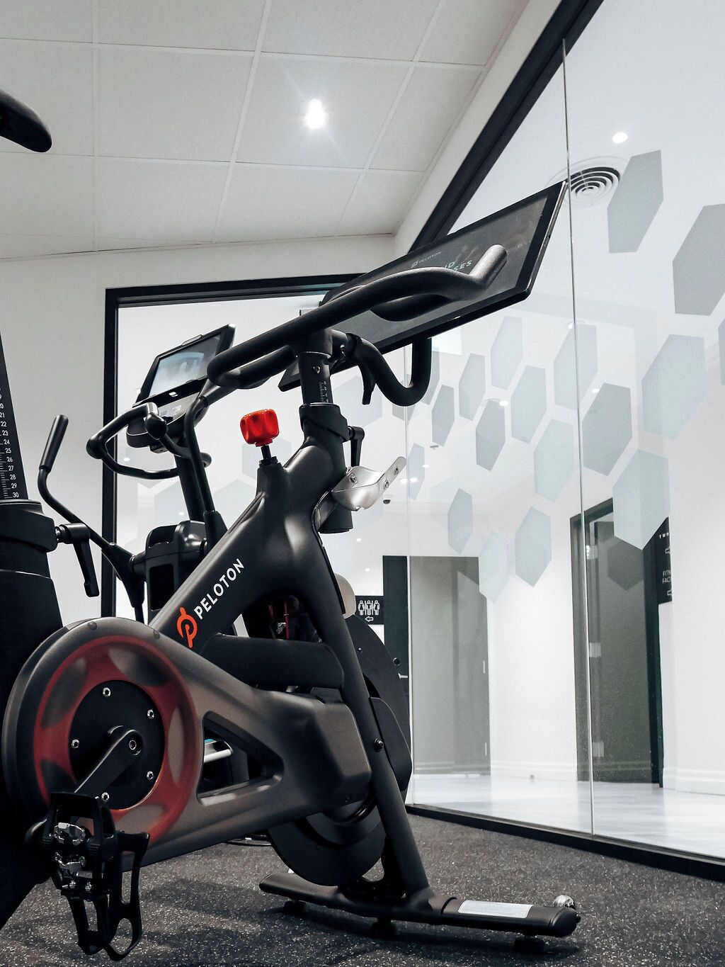 A stationary bike in a gym with a modern design, including a digital display and a red knob.