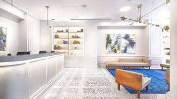 A reception area with a counter, seating, and a large abstract painting.