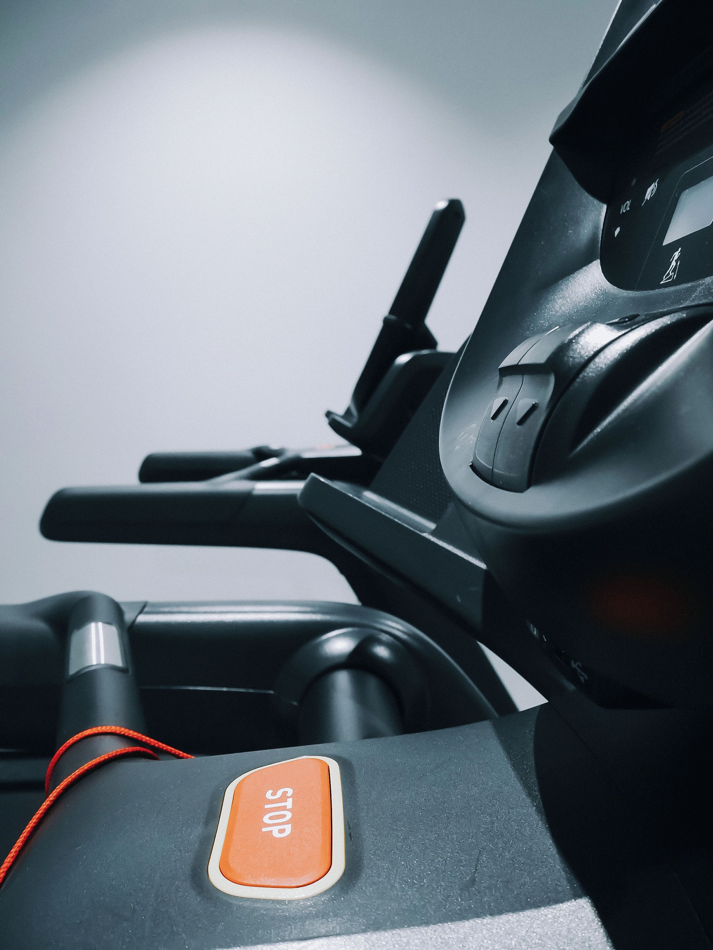 A close-up of a treadmill control panel with a prominent 'STOP' button.