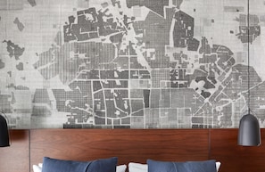 Experience the city in style with a unique city map mural and a comfortable bed.