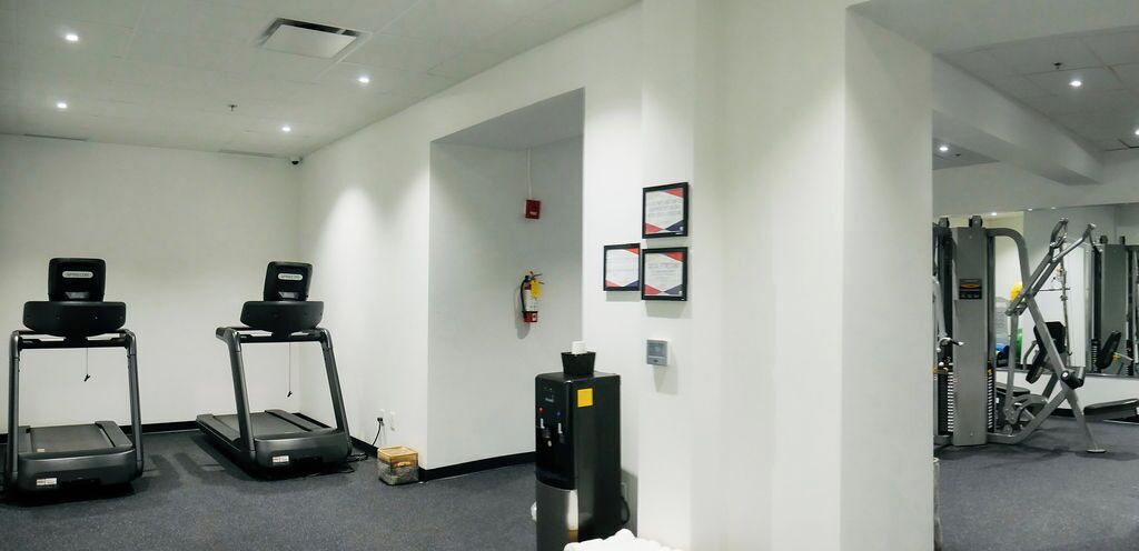 A fitness room with treadmills, a water dispenser, and exercise equipment.