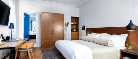 Un dormitorio moderno con una cama de madera, mesitas de noche, un escritorio y un televisor.