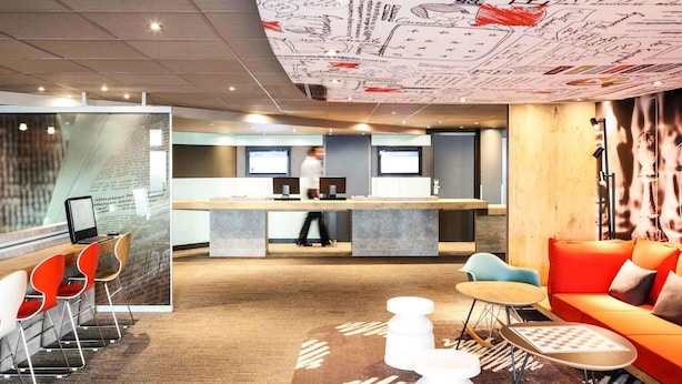 A modern office space with a reception desk, seating area, and a large wall with text and drawings.