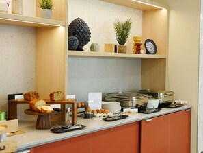 Una mesa de buffet con pan, huevos y diferentes salsas.
