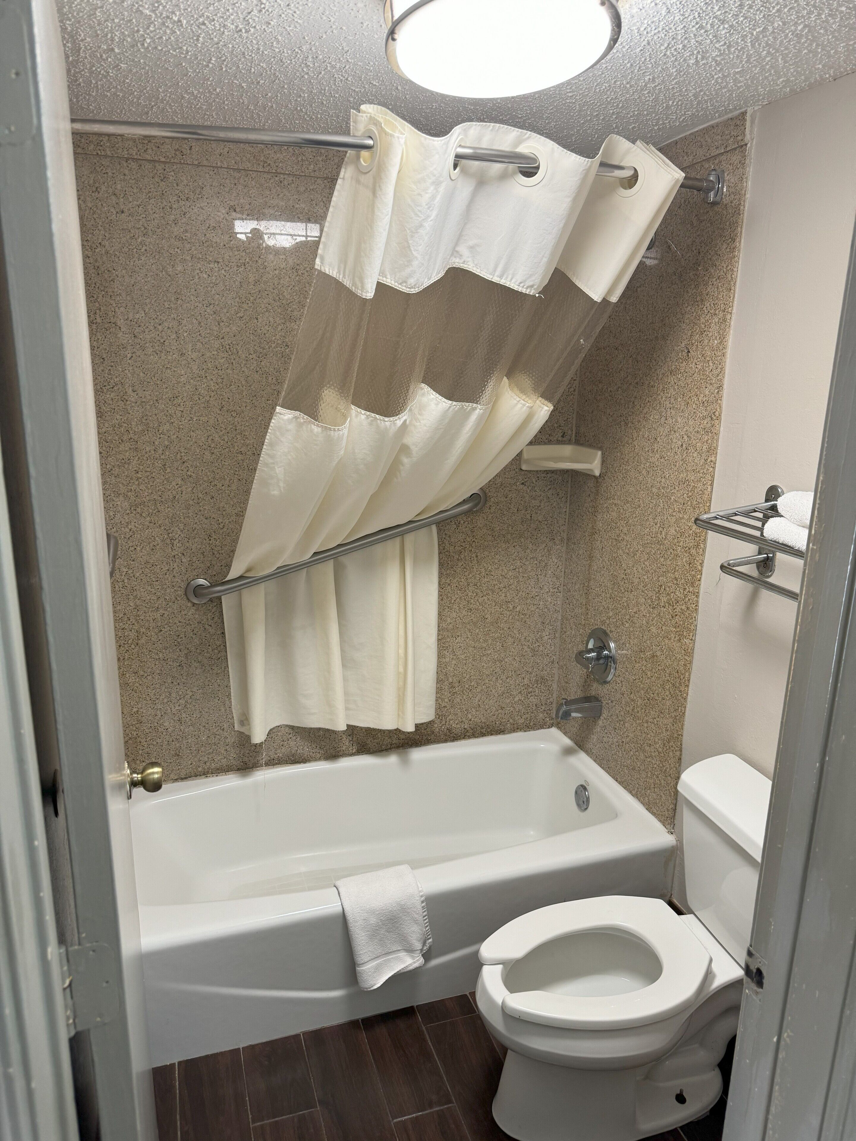 A bathroom with a bathtub, toilet, and shower curtain.