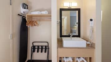 Un baño con lavabo, espejo, toallero y secador de pelo.