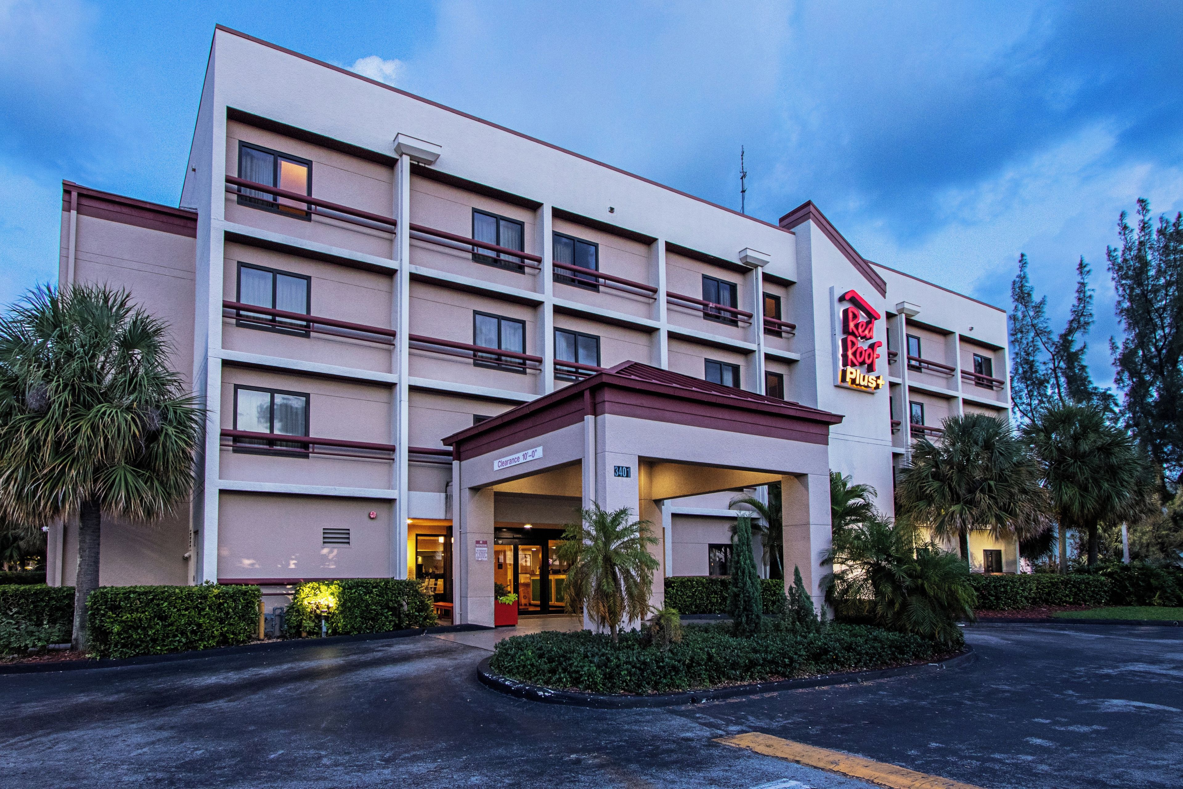Un hotel de varios pisos con fachada plana, acceso cubierto y estacionamiento.