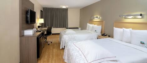 A hotel room with two beds, a desk, a television, and a chair.