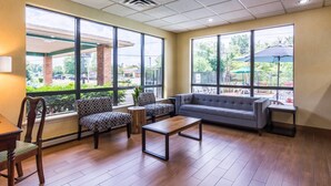 Amplio espacio interior con sofá, sillas, una mesa de centro y grandes ventanales con vistas al exterior.