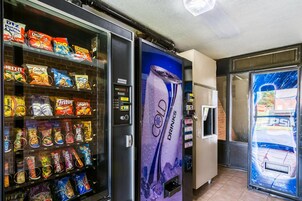 Zona de máquinas expendedoras con diversas opciones de snacks y un refrigerador de Pepsi.