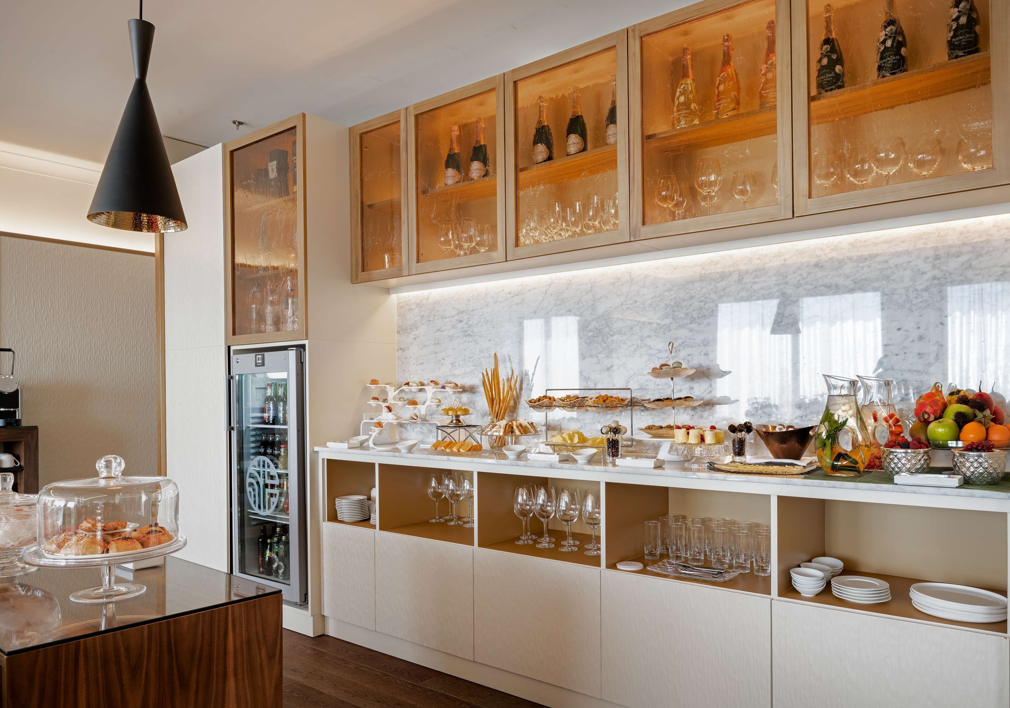 Une chambre d’hôtel équipée d’un buffet pour le petit-déjeuner, d’un réfrigérateur et d’un mini-bar.