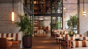 Un restaurant moderne doté d’un long comptoir, de banquettes et d’un plafond haut.