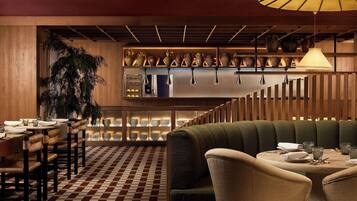 Un interior de restaurante con suelo a cuadros, muebles de madera y una variedad de cerámica expuesta en estantes.