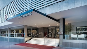 Une entrée moderne d’un immeuble, avec une enseigne indiquant « Eurobuilding ».