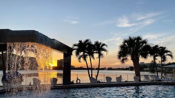 Una piscina al aire libre, sillones reclinables de piscina