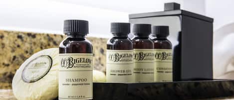 Un meuble-lavabo dans une salle de bain, avec une bouteille de shampoing, un savon et un pot de lotion pour le corps.