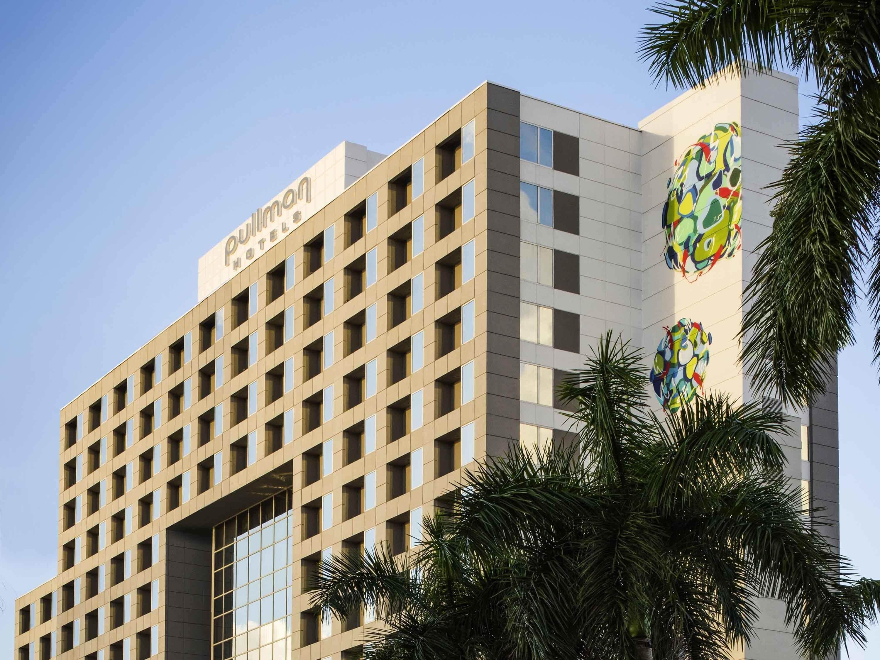 A hotel building with a grid of windows and a sign reading 'Pullman Hotel.'