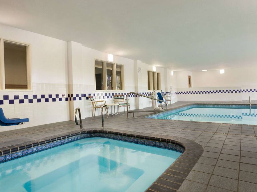 Una piscina interior con suelo de baldosas y un borde a cuadros.