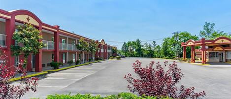 A row of red-roofed motel buildings with a clear sky.