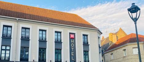 A hotel with a classic facade, multiple windows, and a sign indicating it is a hotel.