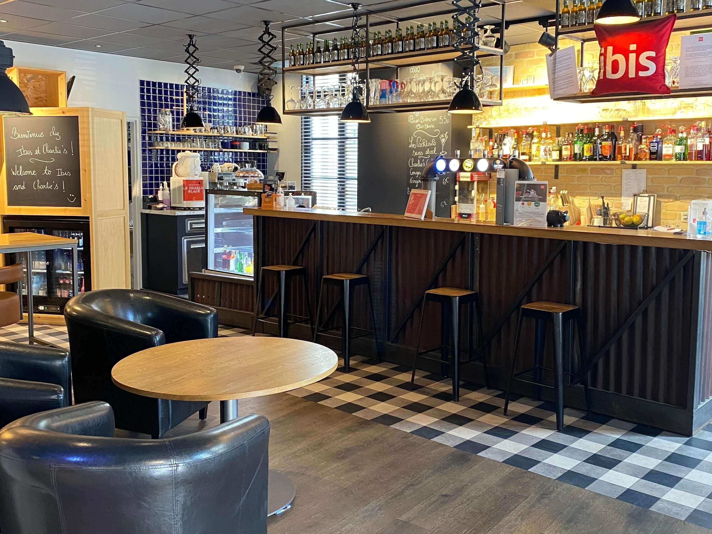 Een bar met krukken, een toonbank en een koelkast.