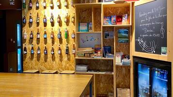 A bar area with wooden shelves, a wall-mounted liquor display, and a chalkboard with text.