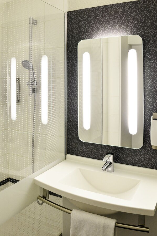 Standaard kamer | Badkamer | Een douche,  milieuvriendelijk toiletgerief, een haardroger, handdoeken