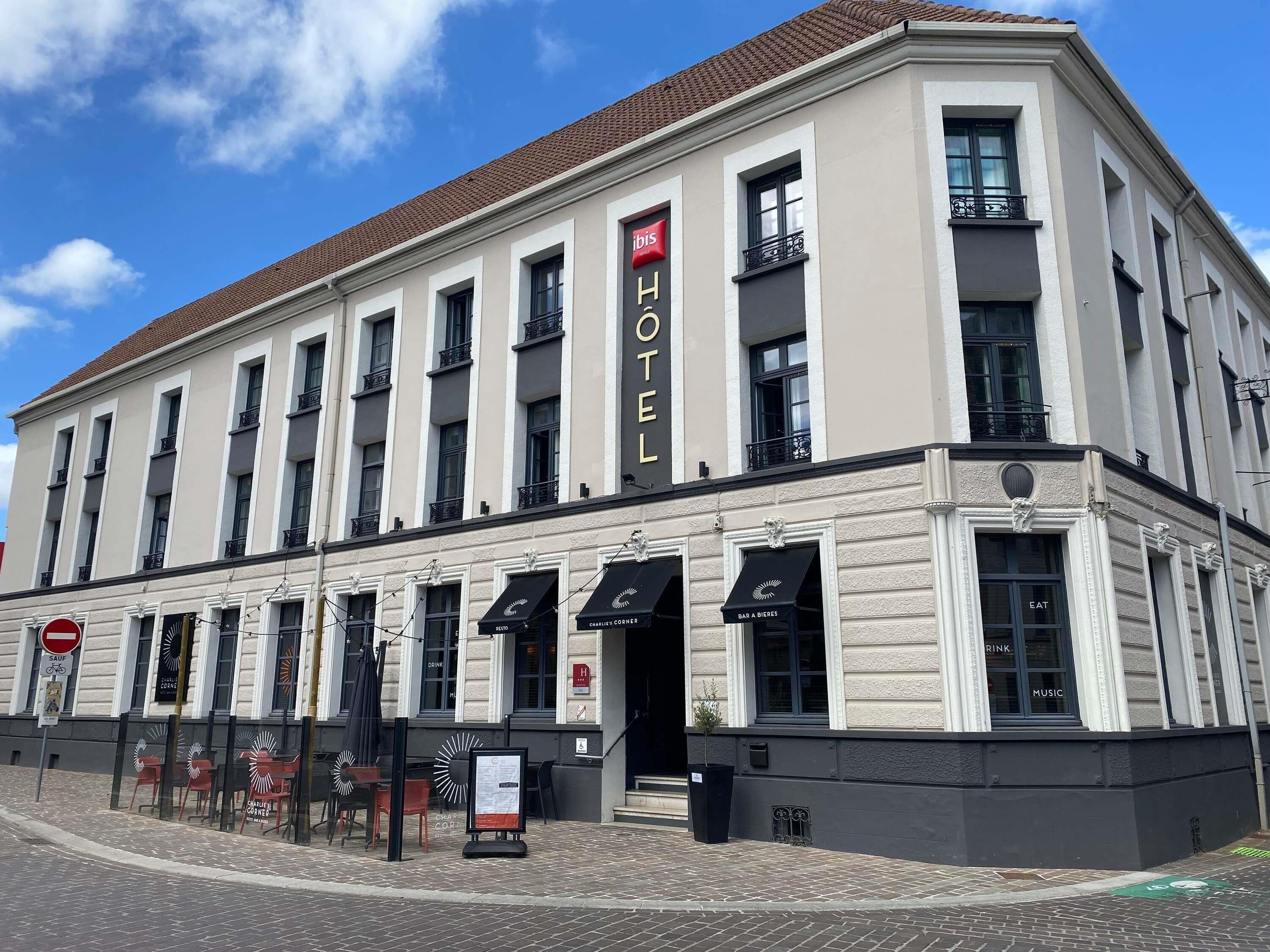 A hotel with a classic facade, multiple windows, and a sign indicating it is a hotel.