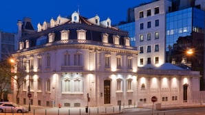 A historic building with classical architecture, featuring a central dome and multiple windows.