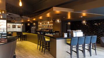 Zona de bar con asientos, barra y estante para vinos.