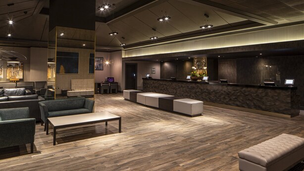 A modern lobby with a reception desk, seating area, and a large window. - Crowne Plaza Harrogate by IHG (Harrogate)