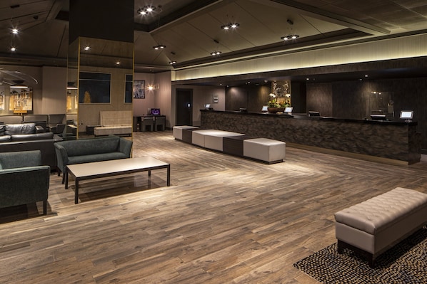 A modern lobby with a reception desk, seating area, and a large window. - Crowne Plaza Harrogate by IHG (Harrogate)