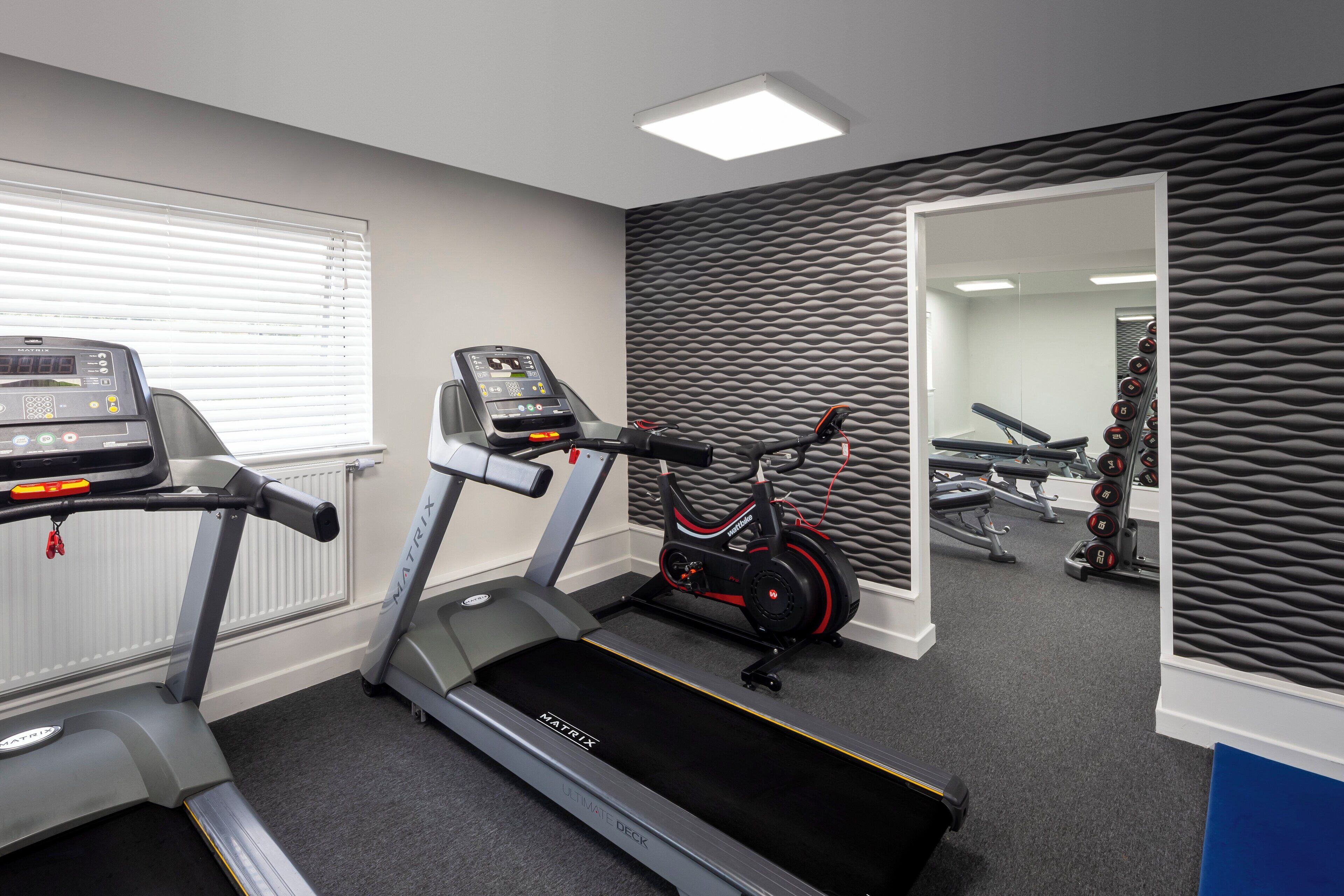 A gym with treadmills, an elliptical, and a stationary bike.
