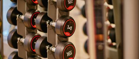 A rack of adjustable dumbbells with weight markings.