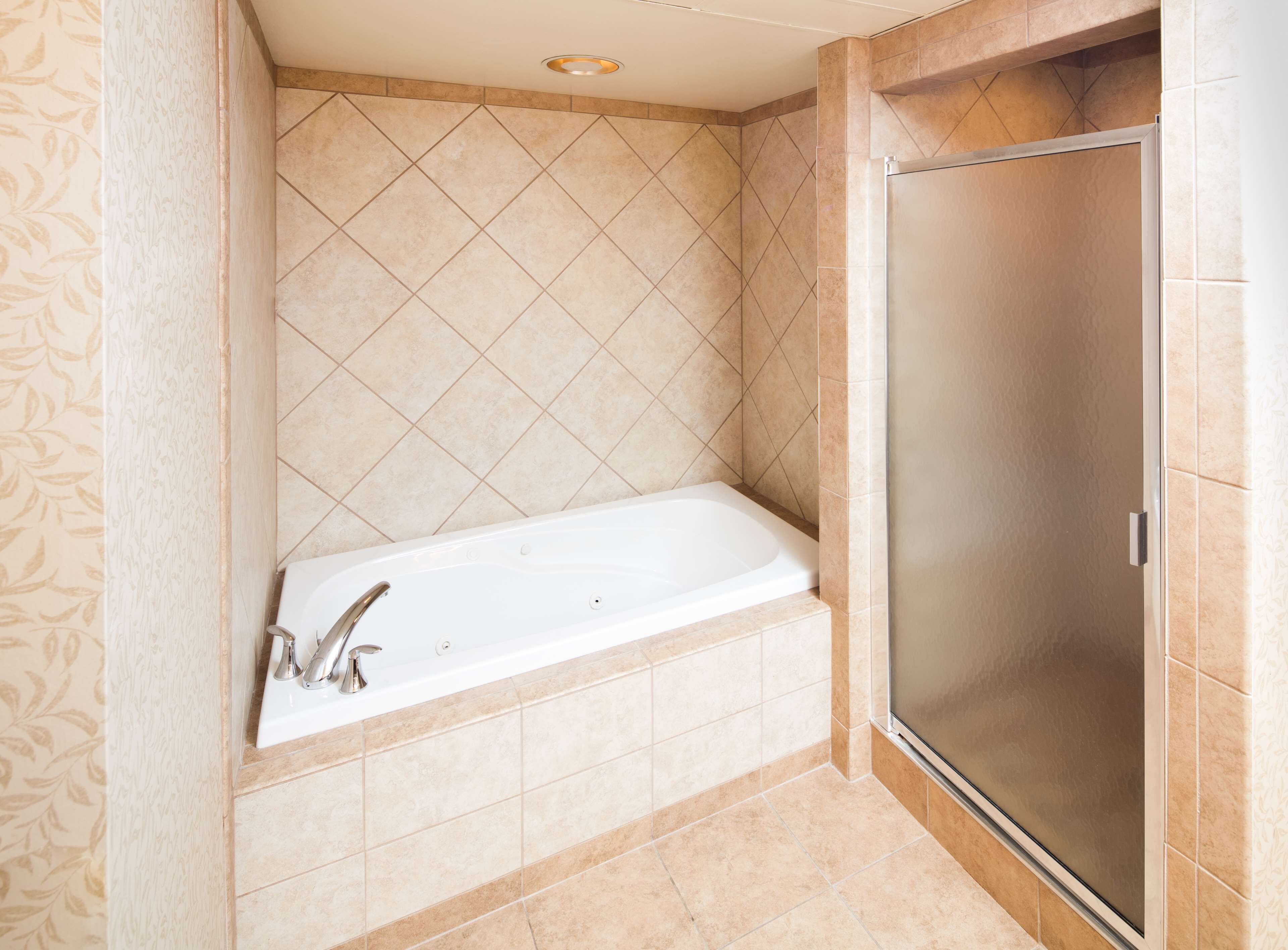 Ein Badezimmer mit Badewanne, Dusche und gefliesten Wänden.
