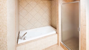 Ein Badezimmer mit Badewanne, Dusche und gefliesten Wänden.