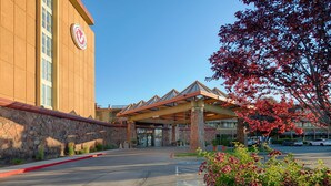 A hotel entrance with a stone facade, a covered entrance area, and a parking lot.