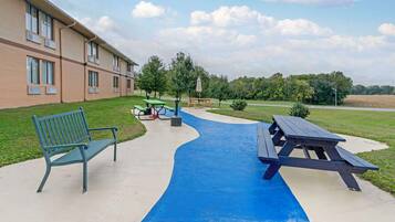 Enjoy a peaceful retreat in this serene outdoor space with a picnic table and bench amidst lush greenery.