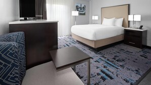 A hotel room with a bed, bedside tables, a desk, a chair, a TV, and a window with curtains. - Hawthorn Extended Stay by Wyndham Chambersburg (Chambersburg)