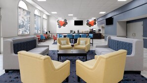 A modern lounge area with sofas and armchairs, a coffee table, and a TV screen.