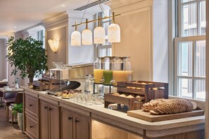 A modern kitchen with a central island, bar area, and a large window. - Radisson Blu Hotel, London Bond Street (London)