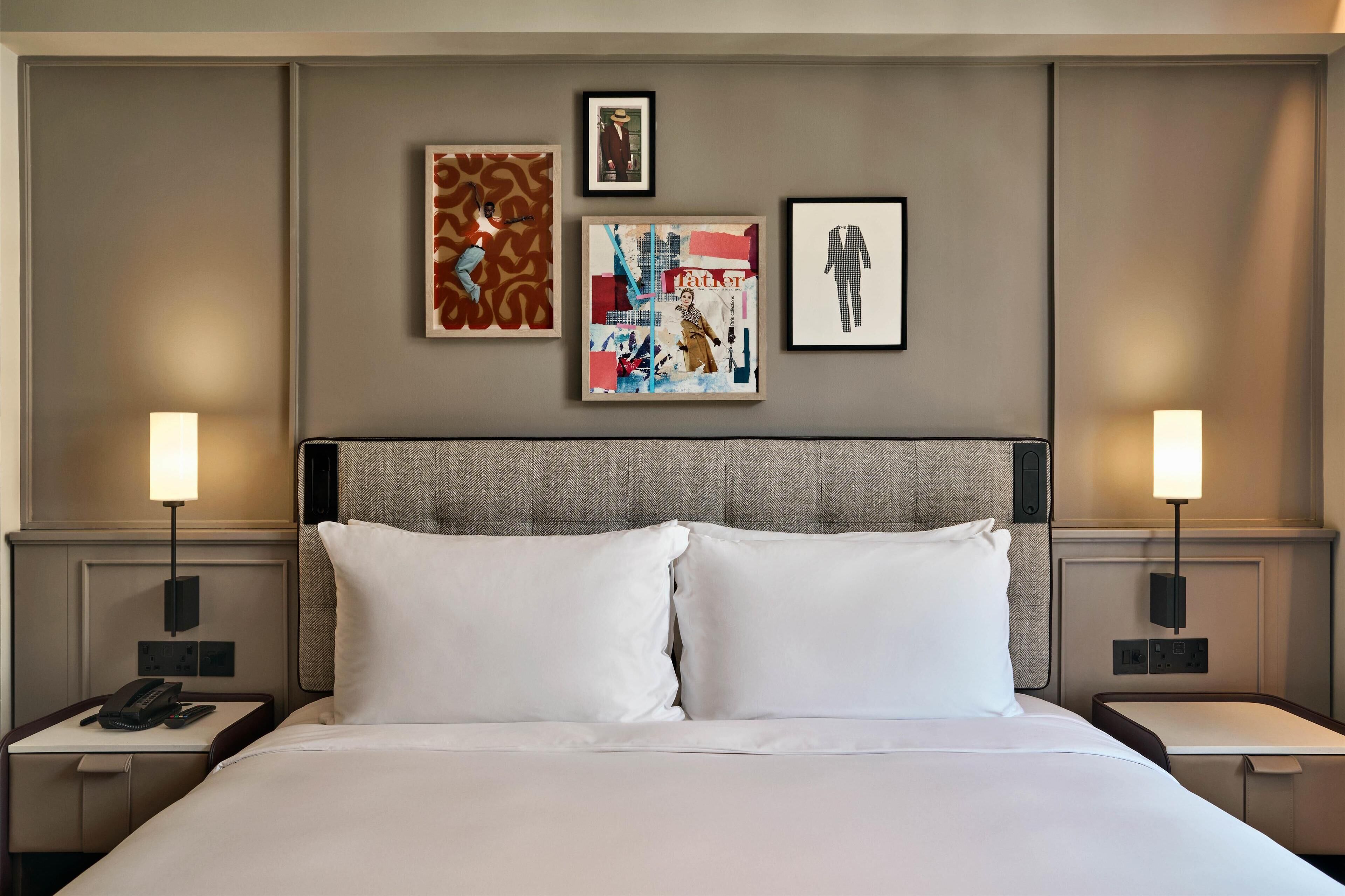 Een hotelkamer met een groot bed, twee nachtkastjes, een hoofdbord en drie ingelijste kunstwerken aan de muur.