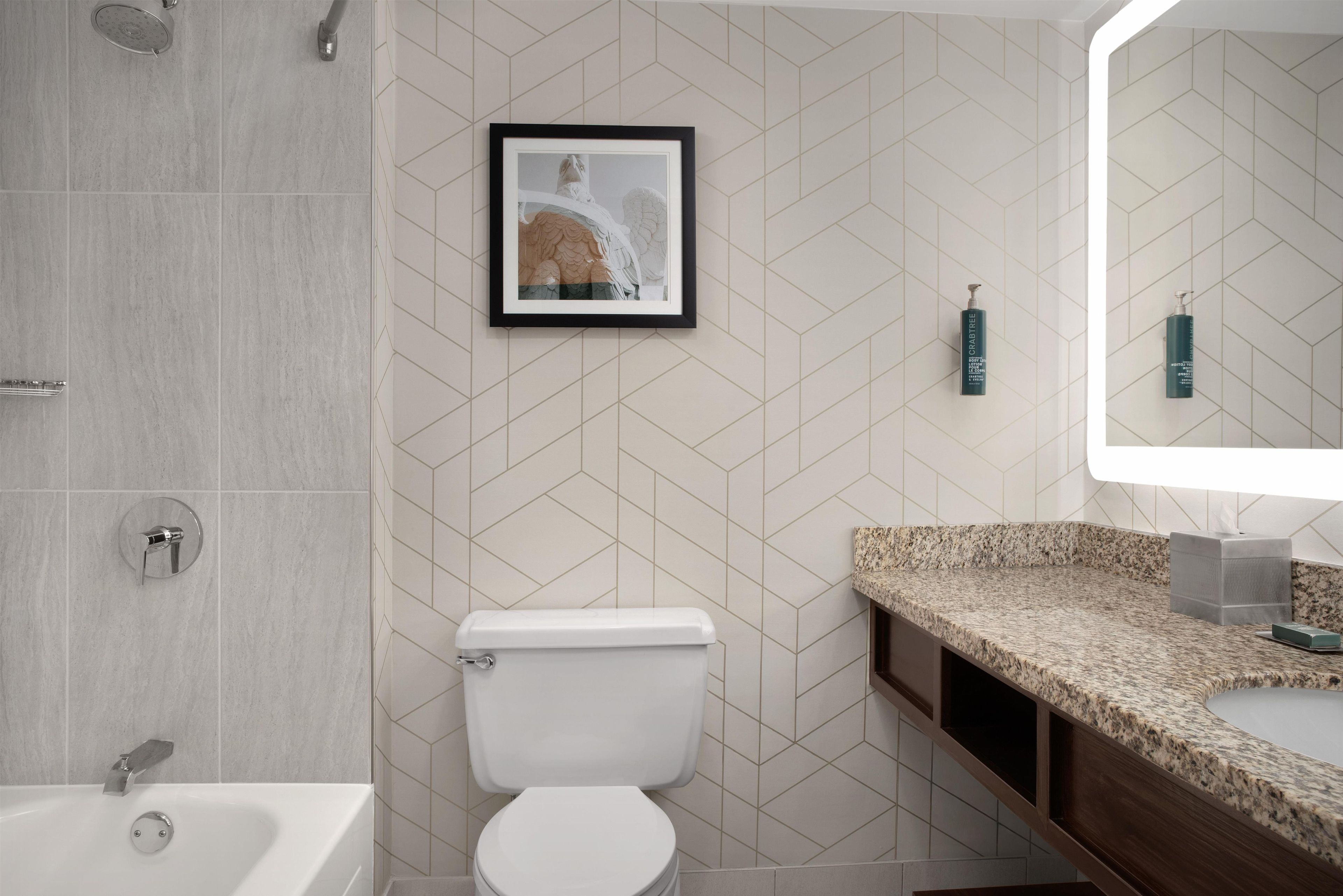 A modern bathroom with a toilet, sink, and shower.